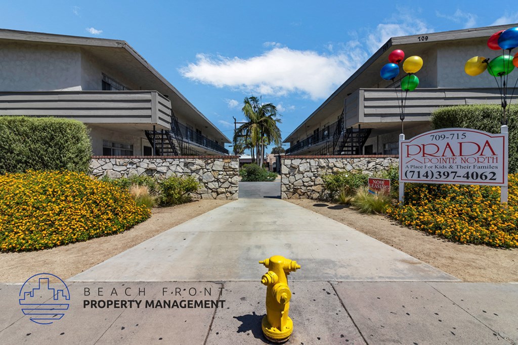 a yellow fire hydrant in front of a building with a sign on the sidewalk